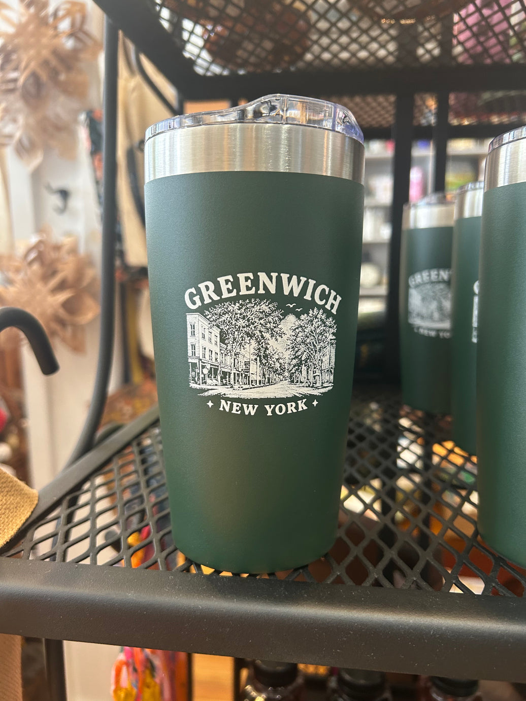 A dark green insulated tumbler with a clear lid and a white printed 'GREENWICH NEW YORK' graphic.